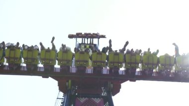 Lunaparkta aşırı cazibeye binen insanlar. Mutlu arkadaşlar eğlence parkı heyecan verici roller coaster binmek eğlenmek