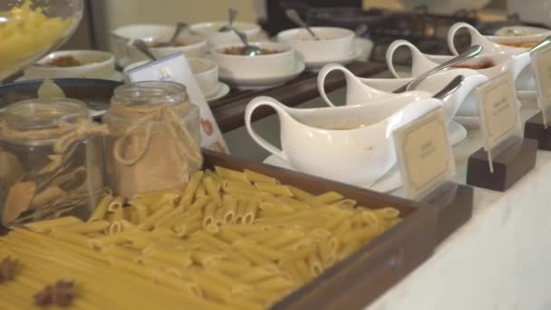 Buffet table in luxury resort hotel restaurant with assorted food, dishes, sauce, tracking shot. Cook preparing scrambled eggs for morning breakfast in all inclusive resort hotel. — Stock Video