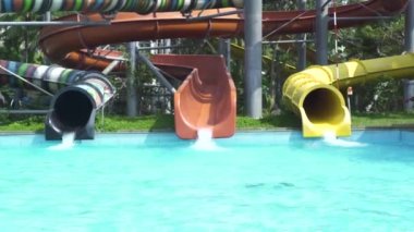 Yaz aquapark mavi yüzme havuzunda renkli su tüpü ve su kaydırak. Lunaparkta açık su parkı.