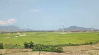 Yeşil alan ve dağ rüzgar santrali üzerinde havadan drone görünümü. Yel değirmeni türbini, rüzgar enerjisi üretiyor. Yeşil teknoloji, temiz ve yenilenebilir enerji çözümü. Alternatif enerji kaynağı.