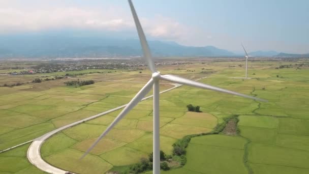 Windmill turbine on green agricultural field and mountain landscape. Drone view wind turbine on power station. Alternative natural resources, renewable energy, ecology and environment conservation. — 비디오
