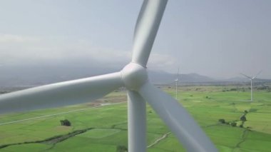 Rüzgar türbinleri insansız hava aracı görüntüsü verir. Temiz yenilenebilir enerji hava görüntüsü için rüzgar jeneratörü. Bulutlu gökyüzü ve dağ manzarasında yeşil alanda yel değirmeni türbini. Alternatif kaynaklar yenilenebilir enerji.