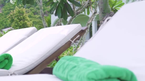 Chaise lounges en parasol op de achtergrond luxe villa en groen gazon. Ligstoelen op groene gazon en wit huisje landschap. Resort Hotel terrirtory. — Stockvideo