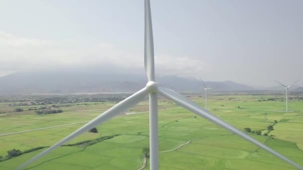 風力タービンはドローンビューを閉じます。緑のフィールドの航空風景の上のエネルギーステーション上の風力発電。自然資源と生態系の保全です代替クリーンで再生可能な代替エネルギー. — ストック動画