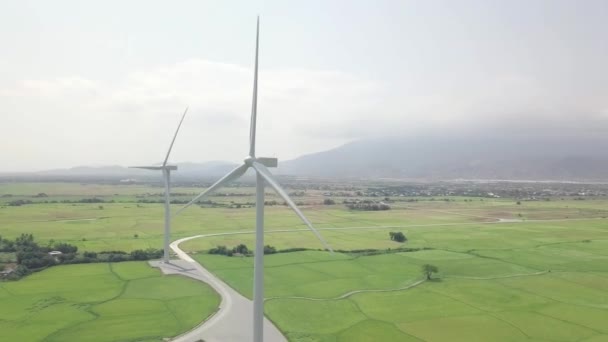 Ветроэнергетическая турбина на зеленом поле и горном ландшафте. Ветряная мельница с видом с воздуха на электростанции. Альтернативные природные ресурсы, возобновляемые источники энергии, экология и охрана окружающей среды . — стоковое видео