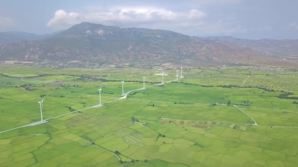Rüzgar enerji istasyonu hava görüntüsü. Yeşil alanda ve dağ manzarasında yel değirmeni türbinleri. Alternatif doğal kaynak ve ekoloji korunumu. Rüzgar üretimi, temiz ve yenilenebilir enerji çözeltisi — Stok video