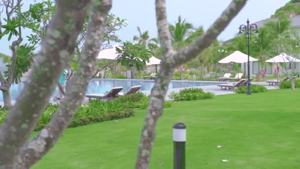 Homme chevauchant en scooter sur fond de piscine bleue à la villa d'été de luxe. Homme gai conduisant scooter passé la piscine à villahotel resort. Vacances d'été . — Video