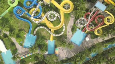 Eğlence aquapark renkli su kaydırağı. Havadan görünüm. Yaz tatilinde açık su parkında kaydıraklarda gezerken eğlenen ler
