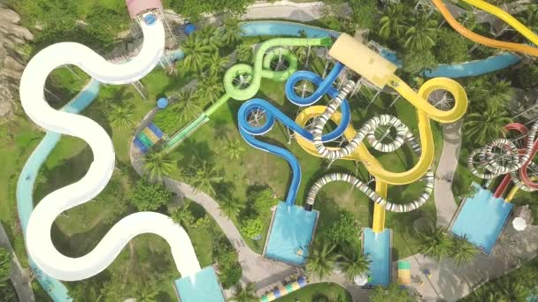 Colorful water slide in amusement aquapark. Aerial view. People having fun riding on slides in outdoor water park. Summer activity. — Stock Video