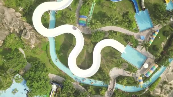 Corrediça de água da vista aérea no aquapark do divertimento. Pessoas se divertindo andando em slides no parque aquático ao ar livre. Actividade de Verão . — Vídeo de Stock