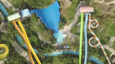 Eğlence aquapark renkli su slaytlar. Havadan görünüm. Yaz tatilinde açık su parkında kaydıraklarda gezerken eğlenen ler.