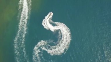 Mavi deniz manzaralı su jeti kayağı kullanan insanlar. İnsansız hava aracı açık denizde jet ski kullanıyor. Yaz tatilinde su sporu. Sucul motor sporu