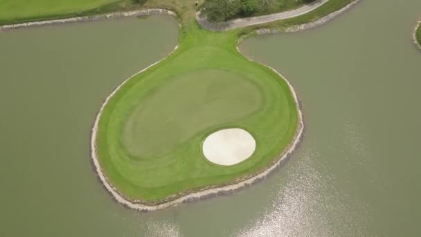 Campo de golf y paisaje del lago de dron volador. Vista aérea campo de golf verde en la isla en el estanque en el club de golf . — Vídeo de stock