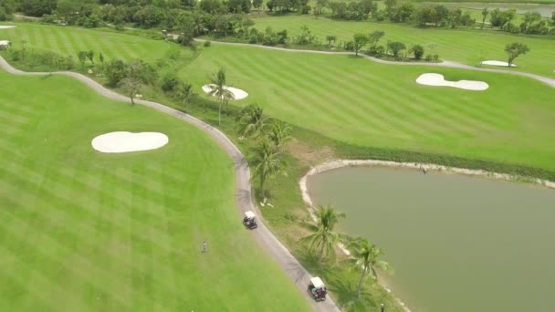 Golfer na zeleném hřišti z letu. Letecký pohled na zelenou oblast v golfovém klubu, v autě a v jezerní krajině. Koncepce sportu a koníčků.