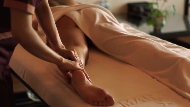 Mladá žena dostává masáž nohou olejem v lázeňském salonu. Dívka dostává masáž těla v luxusním lázeňském centru. Tělesná relaxace a péče o pleť. — Stock video