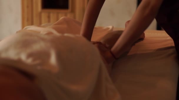 Молодая женщина получает массаж ног маслом в курортном спа-салоне. Девушка получает массаж тела в роскошном спа-центре. Отдых и уход за кожей . — стоковое видео
