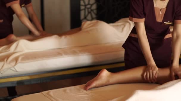 Jonge vrouw krijgt benen massage met olie in kuuroord spa salon. Meisje krijgt lichaamsmassage in luxe spa centrum. Lichaamsontspanning en huidverzorging. — Stockvideo
