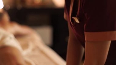 Masaj cılız spa salonunda genç kadına yağ ile bacak masajı yapıyor. Lüks spa merkezinde vücut masajı alan genç kadın. Vücut gevşemesi ve cilt bakımı.