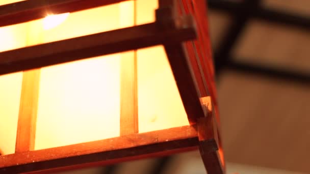 Linterna de iluminación en interior acogedor diseño moderno de cerca. Lámpara de araña de madera y cuadrada para una decoración de iluminación suave y acogedora en el bar, restaurante, apartamento o sala de spa . — Vídeo de stock