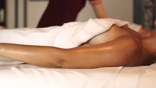Młoda kobieta robi sobie masaż ciała olejkiem w salonie spa. Młoda kobieta otrzymuje masaż dłoni w luksusowym centrum spa. Relaks ciała i pielęgnacja skóry. — Wideo stockowe