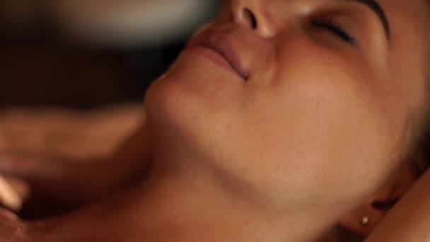Rostro de mujer joven recibiendo masaje en el cuello en el salón de spa cosmético. Masajista haciendo masaje de escote a mujer joven en balneario. Cuidado corporal y de la piel, concepto de belleza . — Vídeo de stock