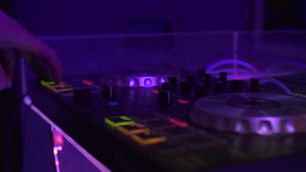Konsol DJ untuk mencampur musik dansa dan warna-warni cahaya di klub disko. DJ mixer player dan sound console untuk pesta dansa techo. Tutup pengontrol disjoki dan pencampuran dek di klub malam . — Stok Video
