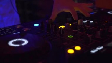 Dj kontrol müzik konsolu ve gece kulübünde renkli ışık. Dj disko partisinde ses konsolunda müzik çalıyor. Renkli ışıklı disk jokey paneli ve karıştırma güverte.