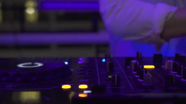 Pengontrol DJ dan konsol musik dalam cahaya penuh warna di pesta dansa di klub malam. DJ mixer player dan konsol suara untuk pesta disko. Panel diska jockey dan dek pencampuran dengan pencahayaan berwarna . — Stok Video