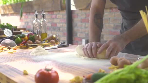 Man Cook kneden deeg voor Italiaanse pasta. Chef-kok koken deeg maken voor pizza en snijden om mes. Proces dat zelf gemaakt gebak maakt. Koken bakkerijproducten, voedsel, zoetwaren concept. — Stockvideo