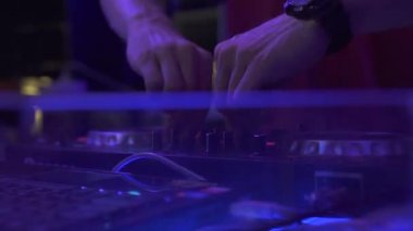 Disko partide ev müziği karıştırma için dj güvertede Erkek el disk jokey. Gece kulübünde ses konsolunda dans müziği çalan erkek dj. Renkli aydınlatma ile Disk jokey paneli ve karıştırma güverte