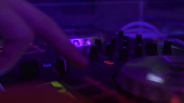 Disko partide techo müzik karıştırma için karıştırma konsolunda erkek el disk jokey. Gece kulübünde ses konsolunda dans müziği çalan erkek dj. Renkli aydınlatma ile Disk jokey paneli ve karıştırma güverte.