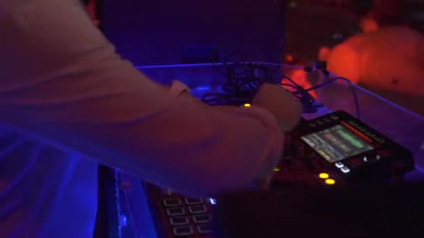 DJ zenélés a keverő konzol a színes fény nightclub. DJ mixer lejátszó és zenei konzol disco Party. A lemezlovas panel és a keverőfedélzet színes megvilágítású