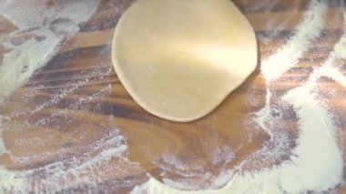 Erkek eller ahşap masada turta pişirmek için hamuru yuvarlıyor. Şef, pizza hamurunu ahşap rulo ile yuvarlıyor. Pastanede pasta ve pasta pişirmek. Ev yapımı yemek ve hamur işi..