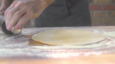 Mutfak masasında pasta pişirme için rulo iğne ile haddeleme hamur. Şef pizzacı rulo ile pizza için hamur haddeleme eller. Pastanede pasta ve kek pişirmek. Evli adam ev yapımı gıda pişirme.