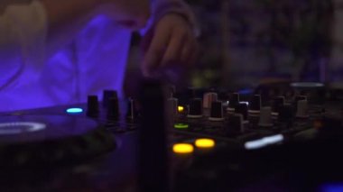 Disko partide techo müzik karıştırma için karıştırma konsolunda erkek el disk jokey. Gece kulübünde ses konsolunda dans müziği çalan erkek dj. Renkli aydınlatma ile Disk jokey paneli ve karıştırma güverte.