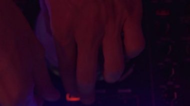 Dans partisinde ses konsolunda müzik çalan Dj elini kapatın. Gece kulübünde müzik ve renkli ışık karıştırma için Dj denetleyicisi. Disk jokey paneli ve dans partisinde karıştırma güverte.