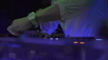 Dj gece kulübünde renkli ışık ses konsolunda müzik çalıyor. Dj mixer çalar ve disko parti için müzik konsolu. Renkli ışıklı disk jokey paneli ve karıştırma güverte