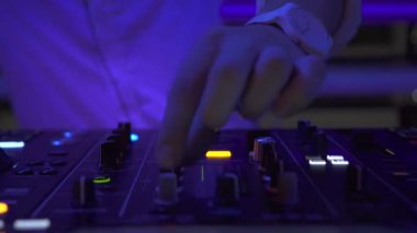 Disko partide techo müzik karıştırma için karıştırma konsolunda erkek el disk jokey. Gece kulübünde ses konsolunda dans müziği çalan erkek dj. Renkli aydınlatma ile Disk jokey paneli ve karıştırma güverte.