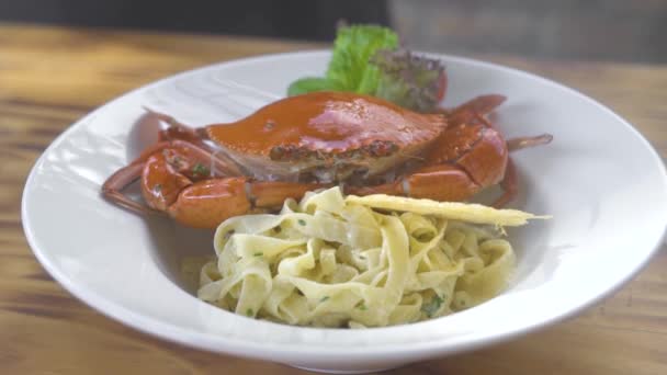 Italienische Meeresfrüchte Pasta mit roter Krabbe und frischem Kräutergewürz auf weißem Teller auf Holztisch. serviert traditionelle Pasta mit Meeresfrüchten auf Restaurantküche. traditionelle italienische Küche. Essen kochen. — Stockvideo