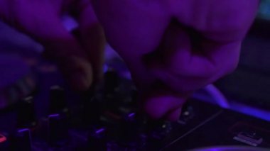 Dj elleri gece kulübünde disko partide karıştırma konsolunda müzik çalıyor. Dj olay partisinde ses konsolunda dans müziği çalıyor. Renkli aydınlatma ile Disk jokey paneli ve karıştırma güverte