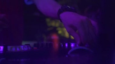 Disko partide techo müzik karıştırma için karıştırma konsolunda erkek el disk jokey. Gece kulübünde ses konsolunda dans müziği çalan erkek dj. Renkli aydınlatma ile Disk jokey paneli ve karıştırma güverte.