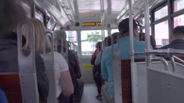 Sokak modern şehirde tramvay sürme koltukta yolcular. Modern şehirde tramvay da sürüş kentsel tramvay yolcu koltuklarında oturan geri bakış insanlar.