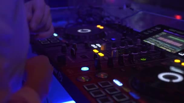 Ελεγκτής DJ και κονσόλα μουσικής σε πολύχρωμο φως σε πάρτι χορού στο νυχτερινό κέντρο διασκέδασης. Player μίξερ και κονσόλα ήχου για ντίσκο πάρτι. Δίσκος ταμπλό και κατάστρωμα ανάμιξης με έγχρωμο φωτισμένο. — Αρχείο Βίντεο