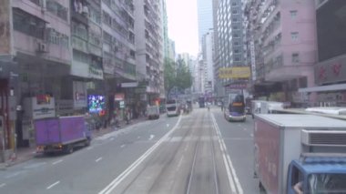 Hong Kong city, Çin - Mayıs 2019: şehir tramvayının arka camından araba yoluna, caddeye ve bina mimarisine bak. Kirli tramvay penceresinden Asya şehrinde modern sokak yolu..