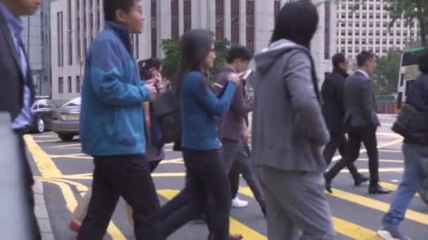 Kota Hong Kong, China - Mei 2019: penyeberangan pejalan kaki di jalan raya kota. Para pebisnis berjalan di persimpangan jalan. Jam sibuk orang di kota maju . — Stok Video