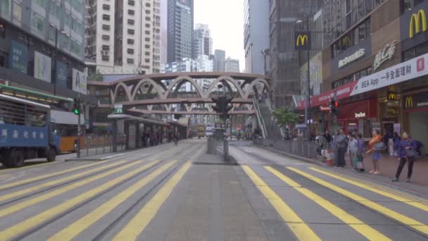 Hong Kong City, China-mei, 2019: auto's en passagiers bus rijden op City Street. Mensen staan op Crossway voor Crossing City Road. Moderne stedelijke architectuur Aziatische stad. — Stockvideo