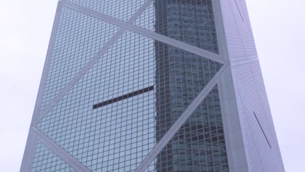 Skleněná fasáda mrakodrap v městské architektuře. Pohled zdola se skleněnou fasádou v moderním městě Hong Kong. Moderní mrakodrapy ve městě na obloze na pozadí. — Stock video
