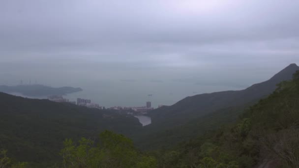Yüksek yeşil dağdan Hong Kong şehrine ve denize inen adaya bak. Modern Hong Kong şehir, adalar ve yukarıdan deniz manzaralı yüzen gemiler. Victoria zirvesinden hava manzarası. — Stok video