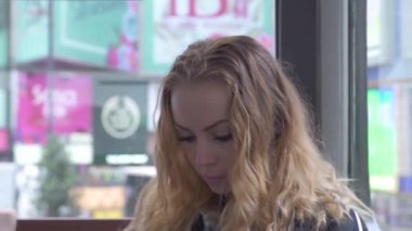 Modern şehirde kentsel tramvay içinde sürerken cep telefonu görünümlü yüz kıvırcık kadın. Portre genç kadın şehir caddesinde hareketli tramvay akıllı telefon kullanarak.