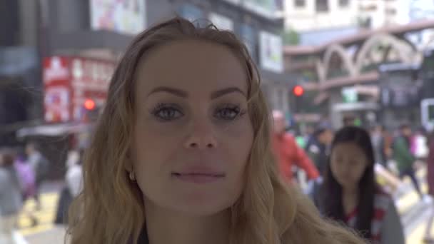 Χαρούμενη γυναίκα στο μοντέρνο ιστορικό του δρόμου της πόλης που κοιτάζει την κάμερα. Πρόσωπο όμορφη γυναίκα με φακίδες χαμογελά και ποζάρει από την κάμερα στο αστικό δρόμο στη μεγάλη πόλη. — Αρχείο Βίντεο